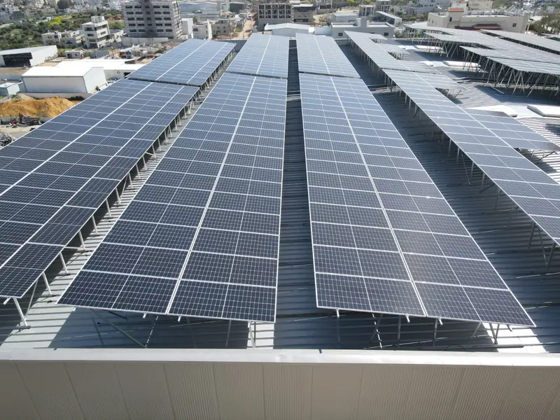 Tetto a falde di un edificio industriale coperto da file di moduli fotovoltaici